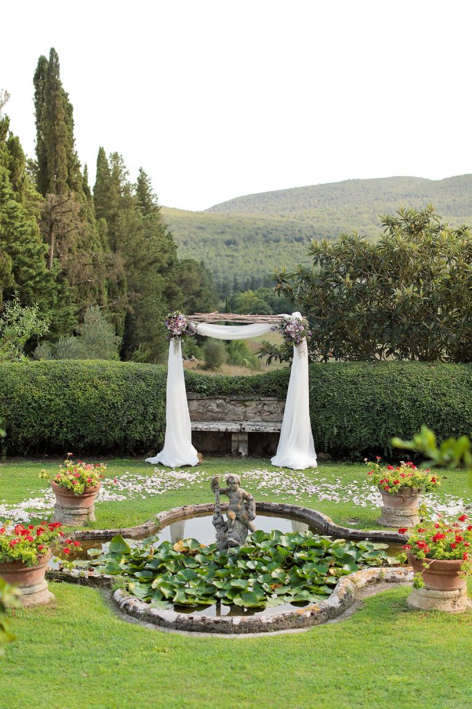 Luxury wedding blessing with secret garden lighting Tuscany arch